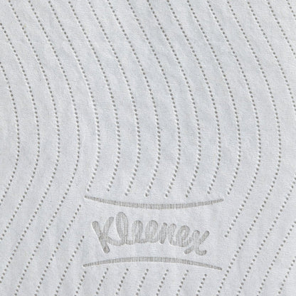 The close-up of a white Kleenex® toilet paper roll from Kimberly-Clark GmbH shows dotted, wavy lines and the gray embossed "Kleenex" lettering, highlighting the high-quality texture of this 8-pack carton (12 small rolls at 250 sheets each).
