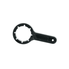 The canister key from Meditrade GmbH is ergonomically made of black plastic and features a round head with six prongs and a flat handle with a hole for easy handling. This tool is ideal for opening 5-liter or 10-liter containers and is presented on a white background.