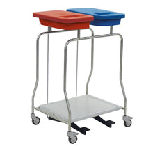 The Novocal stainless steel waste collector "Compact" double collector is a stainless steel cart with wheels, two lid containers - red and blue - for waste separation on the top and a flat lower shelf.