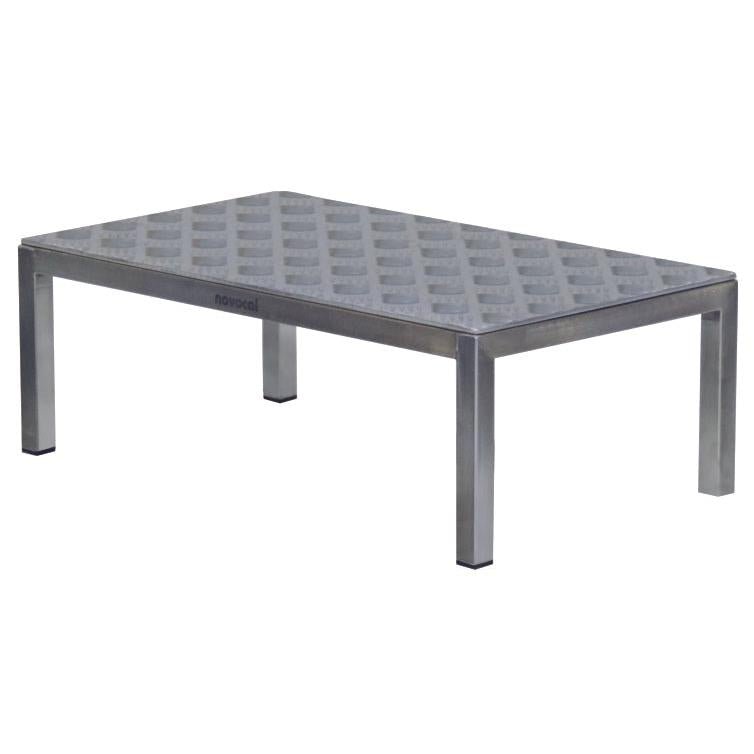 The Novocal OP-Tritt 1 is a rectangular metal table (600 x 350 x 250 mm) with a textured grid plate and four straight legs, branded "Novocal" - ideal as a medical step stool in the operating room. Packaging: 1 piece.