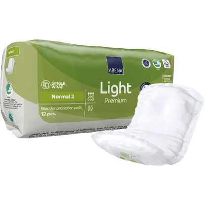 A green-white ABENA Light Normal 2, Premium | Pack (12 pieces) from Abena Re-Seller GmbH stands next to an unfolded insert. The packaging displays product details, symbols, and highlights absorbency.