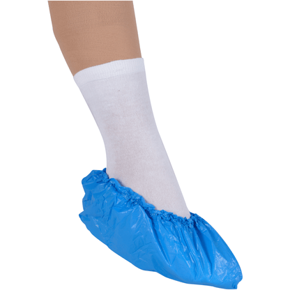 A foot in a white sock is protected by a blue Abena Re-Seller GmbH overshoe, 15 cm 35 my CPE, on a white background for hygienic protection.