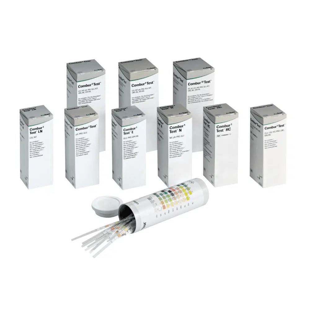 Behind an open cylindrical container with a lid are hidden nine boxes labeled "Combur®" by Servoprax GmbH, each containing 100 Roche urine test strips. On the side of the container is a multicolored chart, which is perfect for conducting a quick test.