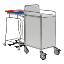 The Novocal station trolley features a stainless steel frame with fully welded joints, four wheels, a white cabinet with handle and door, as well as two rear waste bins - one with a red lid and one with a blue lid - ideal for care facilities.