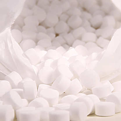 Numerous white, round tablets fall from an opened white bag of AXAL PRO TABS regenerating salt by K+S Minerals and Agriculture GmbH onto a surface, perfect for water softening.