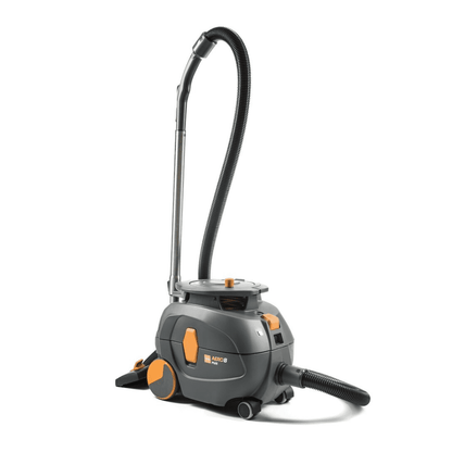 A TASKI AERO 8 PLUS vacuum cleaner, provided by Diversey Deutschland GmbH & Co. OHG, in gray and orange, stands upright. This compact and powerful canister vacuum features a long flexible hose and has a cylindrical body with large rear wheels and smaller front wheels for excellent mobility and efficient cleaning. Its operation is enhanced by whisper technology for quiet operation.