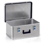 A rectangular Novocal aluminum transport box with a hinged lid, black handle, and two blue locks. The open lid reveals an empty interior. The exterior has a textured surface. Contains one stackable unit per pack.