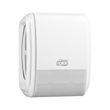 A Tork 256010 dispenser for continuous air freshener with nebulization technology for a refreshing touch is mounted on the wall. Its sleek design includes a semi-transparent bottom that shows the roll inside, while the Tork logo is prominently displayed in the center to enhance your restroom experience.