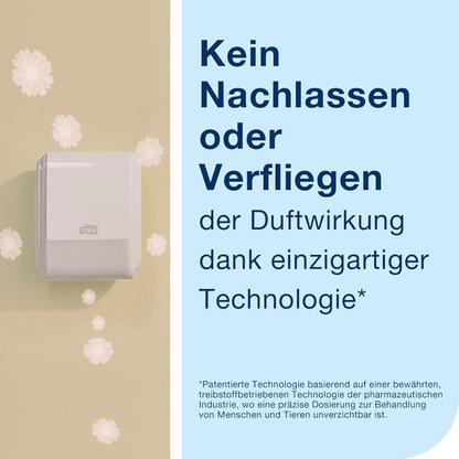 The Tork 256010 dispenser for continuous air freshener is mounted on a beige wall. The background text in German emphasizes the effectiveness of the product through its unique nebulization technology. White, fluffy particles float around, resembling a distributed scent and enhancing your restroom experience.