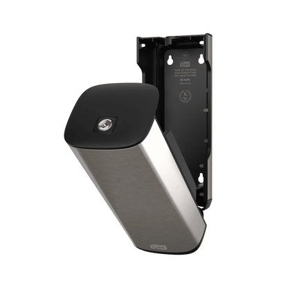 A Tork 460010 dispenser for soap and hand sanitizers in stainless steel and black from Essity Professional Hygiene Germany GmbH for wall mounting with an open front panel that reveals the interior compartment. This modern design also features a partially detached plate that exposes the interior bracket and screw positions.