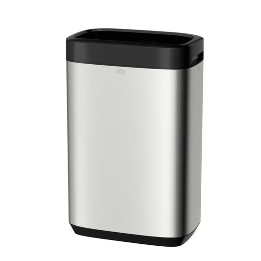 The Tork 460011 Tork Image Line Waste Bin, presented by TORK – Essity Professional Hygiene Germany GmbH, is a sleek and minimalist rectangular stainless steel trash can with a black lid and base. Its stainless steel design offers a generous 50-liter capacity, combines style with functionality, and features a small handle for easy opening.