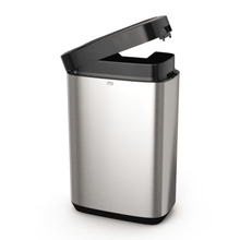 The Tork 460011 Tork Waste Bin from the Image Line series by TORK – Essity Professional Hygiene Germany GmbH features a slightly open stainless steel design with a black sensor-activated lid. Its sleek stainless steel design offers a capacity of 50 liters and a rectangular shape with a smooth surface, ideal for modern spaces.