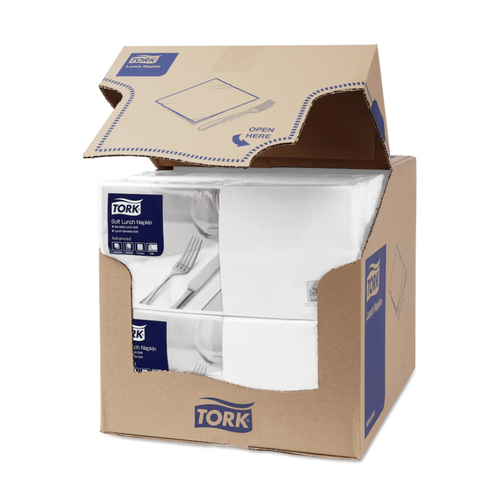 A carton of Tork 477414 Soft Lunch Napkins White Advanced 3-ply is partially open, revealing four stacks of three-ply, industrially compostable white napkins. The carton displays the blue and white TORK branding - Essity Professional Hygiene Germany GmbH, along with product information and a clear 'Open here' instruction on the top flap.