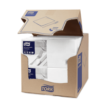 A carton of Tork 477414 Soft Lunch Napkins White Advanced 3-ply is partially open, revealing four stacks of three-ply, industrially compostable white napkins. The carton displays the blue and white TORK branding - Essity Professional Hygiene Germany GmbH, along with product information and a clear 'Open here' instruction on the top flap.