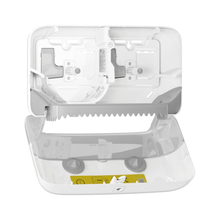 The Tork 558040 double roll dispenser for coreless Midi toilet paper Elevation T7 from Essity Professional Hygiene Germany GmbH features an open design with transparent sections, highlighting the internal mechanisms and eco-friendly functionality for holding and dispensing. It features a visible serrated edge, a yellow instruction label, and is compatible with coreless Midi toilet paper.
