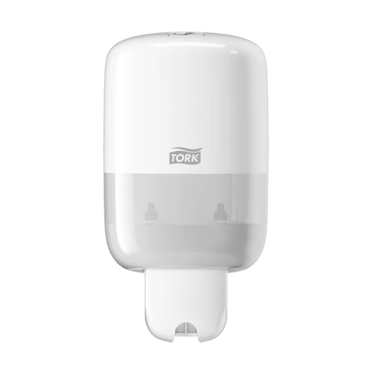 The Tork 561000 Mini Dispenser for Liquid Soap Elevation S2, manufactured by Essity Professional Hygiene Germany GmbH under the TORK brand, features a sleek and modern Elevation design with a transparent lower part for easy wall-mounting. The distinctive Tork logo is visible on the front, while the bottom contains an efficient dispensing slot.