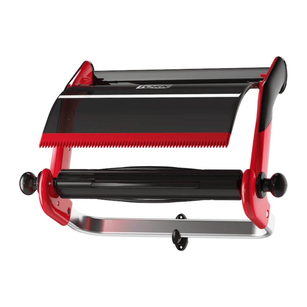 A roll holder from the brand TORK – Essity Professional Hygiene Germany GmbH with the designation "Tork 652108 roll dispenser wall mount Performance W1" is mounted on the wall. It features a serrated edge for cutting and includes a rod for holding foil or cling film. It seamlessly combines smooth metal and plastic components, thus efficiently improving kitchen organization.