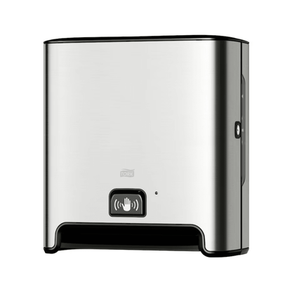 A TORK Tork Matic® 460001 sensor dispenser for roll towels Image Line made of stainless steel for wall mounting with sensor H1 | Pack (1 piece) with black base and sensor display symbol on the front. This dispenser, designed for touch-free single sheet dispensing, features a modern, simple appearance and uses roll towels to ensure a hygienic experience.