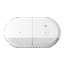 The Tork SmartOne® 682000 Mini Twin Roll Dispenser for Toilet Paper T9 from Essity Professional Hygiene Germany GmbH is a white twin toilet paper dispenser with a transparent bottom that cleverly accommodates two rolls. Its sleek, rounded design makes it an excellent choice for commercial or public toilets, offering both functionality and elegance.