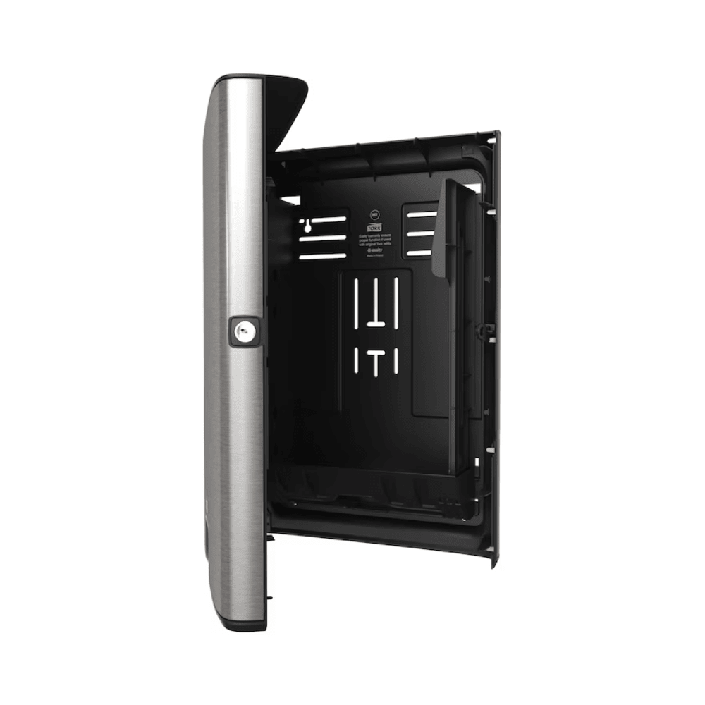 The Tork Xpress® 460004 dispenser for folded hand towels from the Image Line H2 collection, offered by Essity Professional Hygiene Germany GmbH, features an open and empty casing with a modern vertical design and a CO2-neutral metallic surface on the left side. Its black interior is equipped with compartments and ventilation openings and is complemented by a hinged door that enhances its functionality.