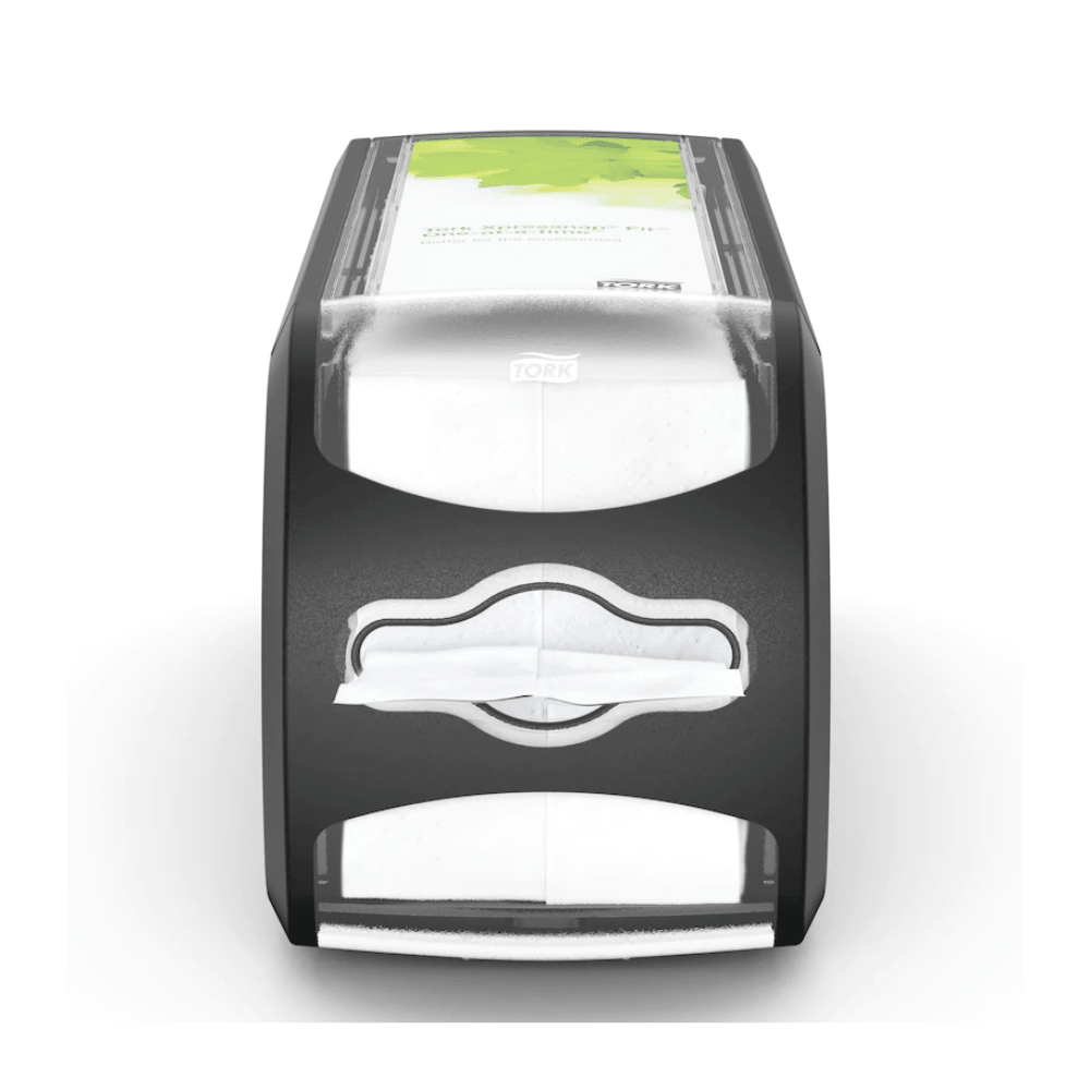 Pictured is the napkin dispenser Tork Xpressnap Fit® 272901 from Essity Professional Hygiene Germany GmbH. This black-gray dispenser has a transparent front containing white napkins and a green advertising space on the top. The 'Tork' logo is visible and highlights the efficient single napkin dispensing system of the Tork Xpressnap Fit.