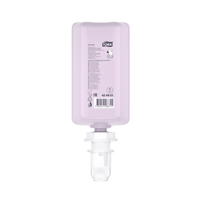 A pink, rectangular bottle of Tork luxurious liquid soap with a white cap is displayed. It shows product details and a barcode and contains luxurious liquid soap with natural ingredients, enriched with magnolia extract. This refill is positioned upside down for easy insertion into a dispenser and is part of a set from the TORK brand of Essity Professional Hygiene Germany GmbH.