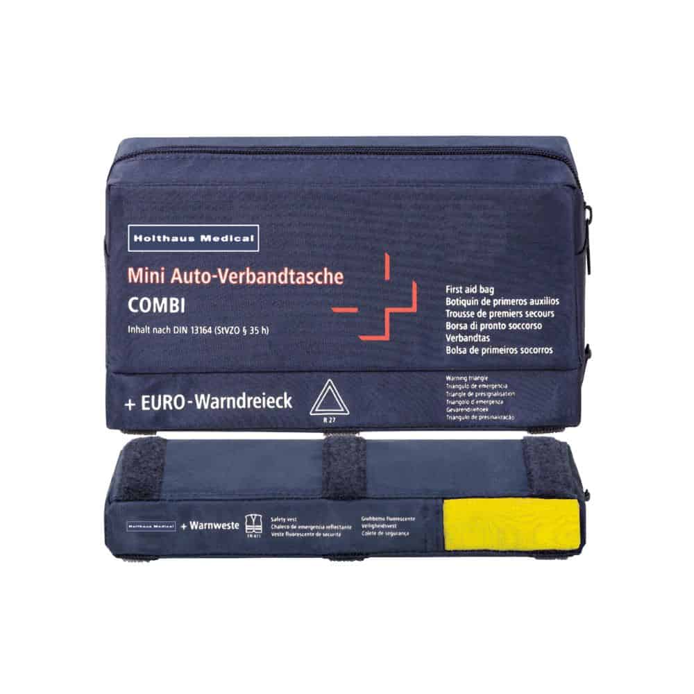 A mini first aid kit COMBI Auto from Holthaus Medical GmbH & Co. KG is in blue and shows multilingual labeled contents. This first aid kit contains a warning vest and a warning triangle, with the yellow vest clearly visible at the bottom.
