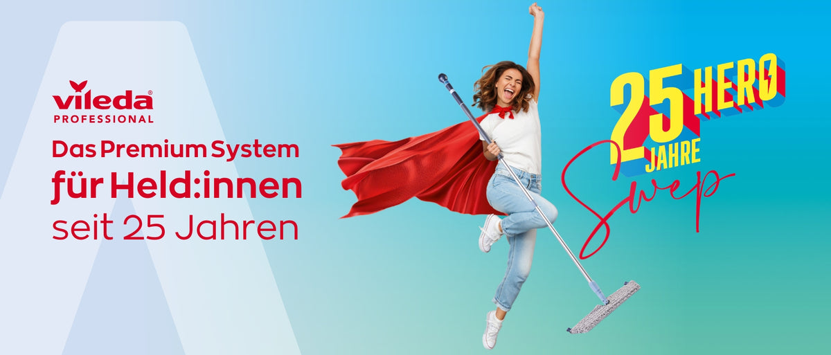 Eine Frau mit rotem Umhang und weißem Hemd springt in die Luft und hält einen Mopp in der Hand. Der Text lautet: "Vileda Professional. Das Premium System für Held:innen seit 25 Jahren. 25 Jahre Hero Sweep." Blauer Hintergrund.