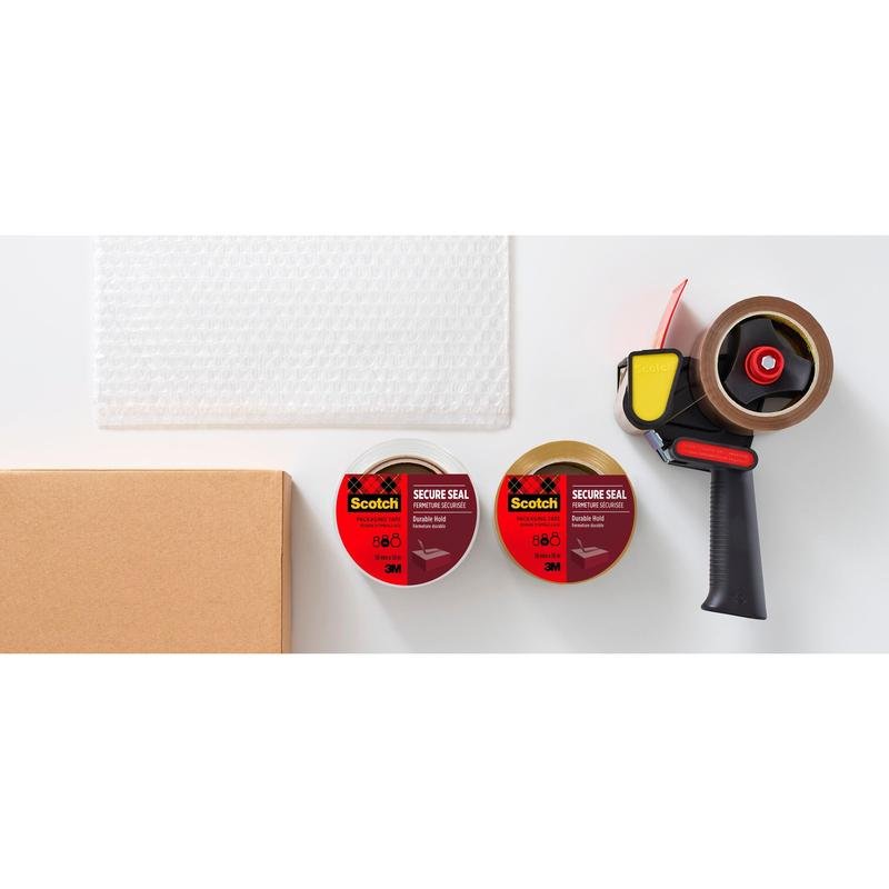 On a white surface lies a cardboard box, bubble wrap, two rolls of Scotch® packaging tape for secure sealing (50 mm x 50 m) from 3M Deutschland GmbH, and a black-yellow tape dispenser.