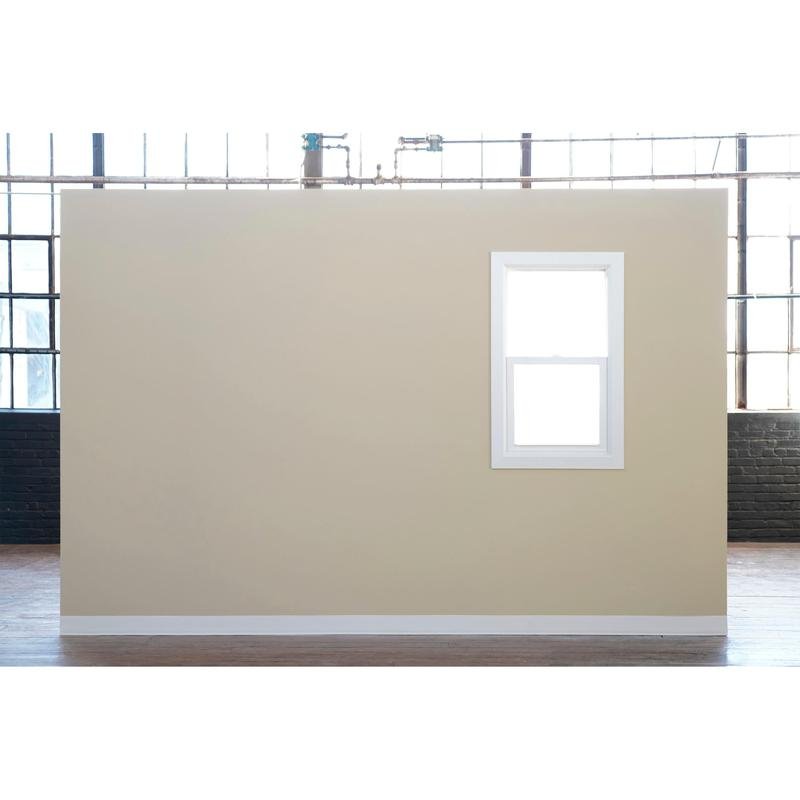 A beige wall with a white-framed window stands in front of large industrial windows - ideal for painting with Scotch® Classic masking tape, 24 mm x 50 m, from 3M Deutschland GmbH (70% PEFC, SGSCH-COC-110078) - in a large room with a wooden floor.