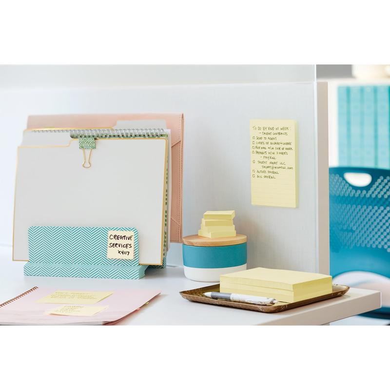 On the tidy desk, there is a file folder from 3M Deutschland GmbH with binders and a clipboard, a container with stacked Post-it® Super Sticky Notes (76 mm x 76 mm, promotion, 90 sheets/block, 100% PEFC), a golden tray with more notes and a pen, and a weekly planner.