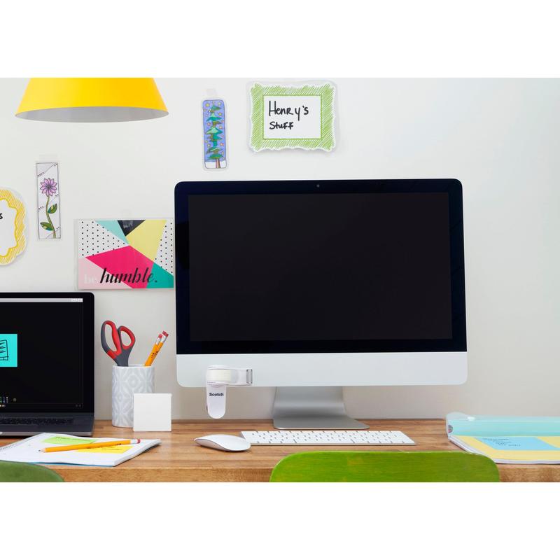 A tidy desk with a large monitor, a closed laptop, a cup with pens and scissors, office supplies, and the 3M Scotch™ Clip & Twist Tape Dispenser C19 with Magic™ Invisible Tape on display. Decorative notes like "Henry's Stuff" are on the wall.