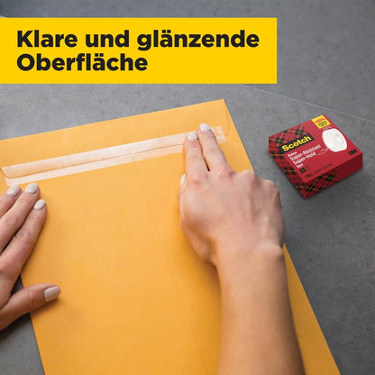 A person seals a brown envelope with Scotch® Super-Hold Secure Tape, 1 roll, 19 mm x 25.4 m from 3M Deutschland GmbH. On the gray surface is a red Scotch dispenser box; above it is the text "Clear and shiny surface."