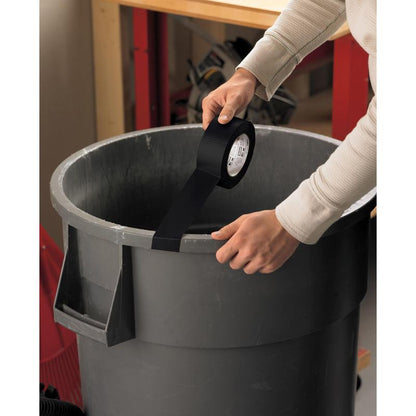 A person applies Scotch® Universal Tape 2904 (50 m x 48 mm) from 3M Deutschland GmbH to the edge of a large gray trash can in a workshop, with a workbench and tools in the background.