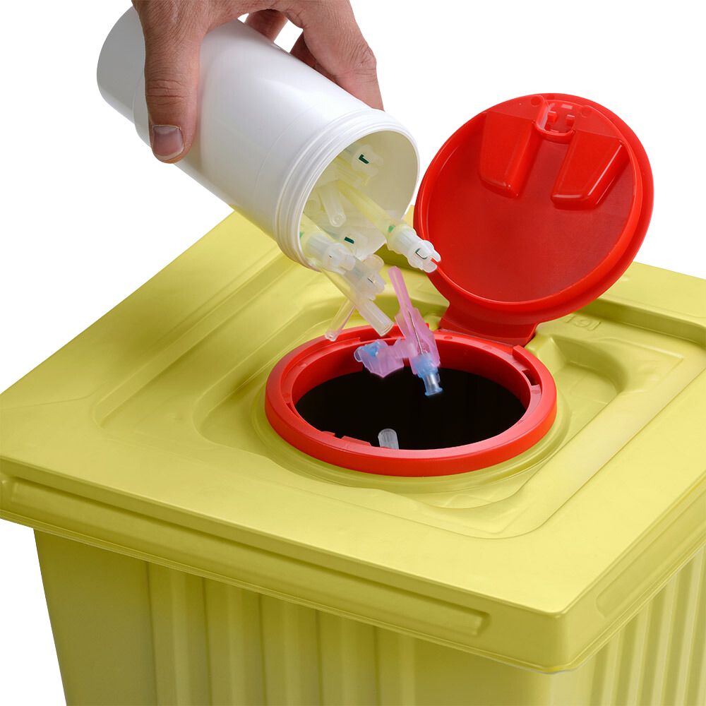 A hand disposes of used syringe tips from a white Helmut Schwarz GmbH melijekt disposal container 12 L into a yellow medical waste container with a red lid, ensuring proper disposal.