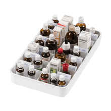 The melipul Anbruchtropfen tablet with 14 compartments from Helmut Schwarz GmbH elegantly arranges a selection of homeopathic bottles and boxes and presents a clear selection of liquid medications. The compartments contain containers in various sizes and colors, mainly brown glass bottles and white boxes, some with visible labels.