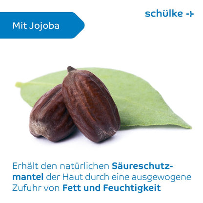 Two jojoba seeds rest on a green leaf against a white background. The image contains German text describing the benefits of Schülke sensiva® protective emulsion for maintaining the skin's acid mantle with balanced fat and moisture supply, similar to the fragrance-free protective lotion. The brand name “Schülke & Mayr GmbH” appears in blue.