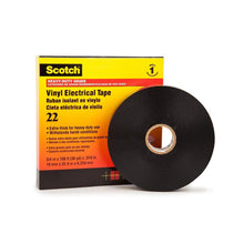 Schwarze Klebebandrolle neben gelb-roter Verpackung, freigestellt auf hellem Hintergrund mit klar sichtbaren Kanten.